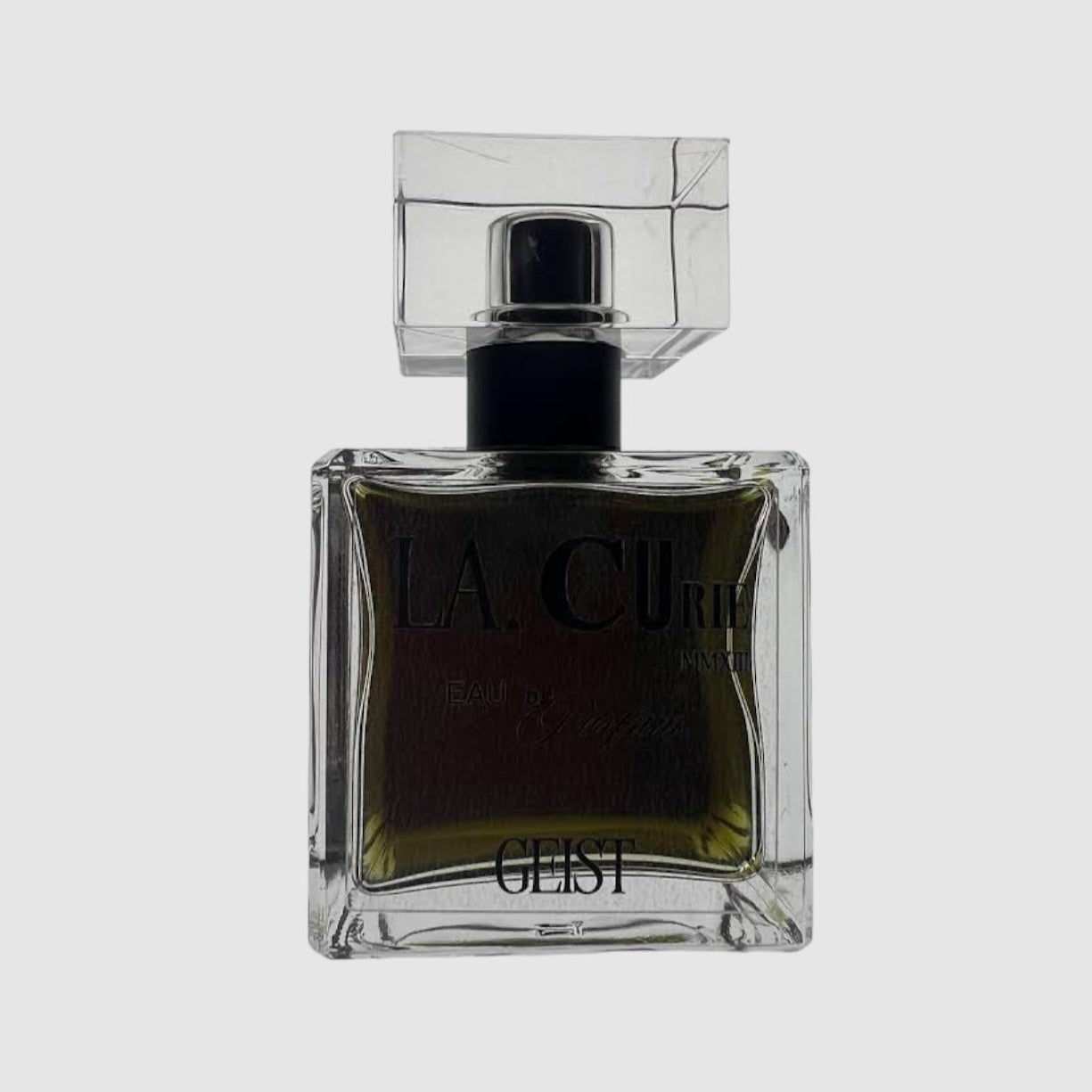A square glass perfume bottle with a black cap, labeled 'LA CURIE GEIST'.