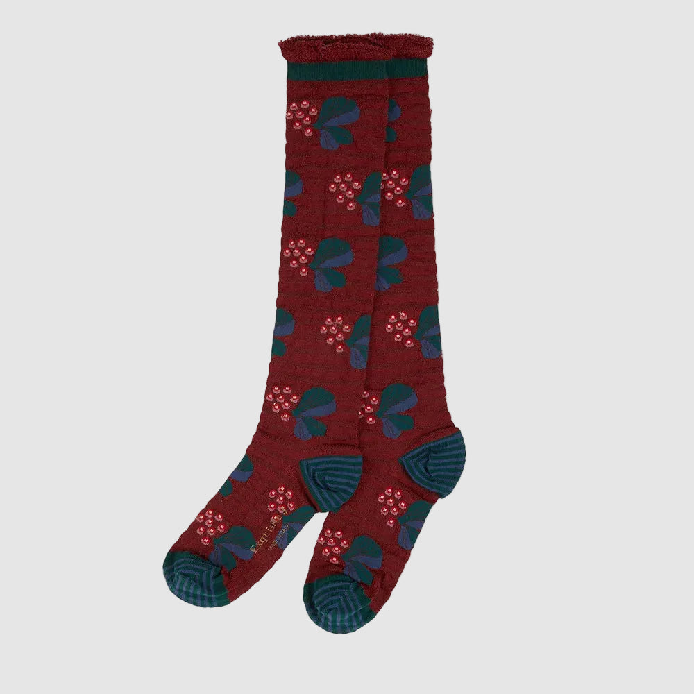 A pair of knee-high textured socks in a deep burgundy red, featuring a repeating pattern of dark teal leaves and small pink berry clusters, with solid dark teal heels, toes, and cuffs.