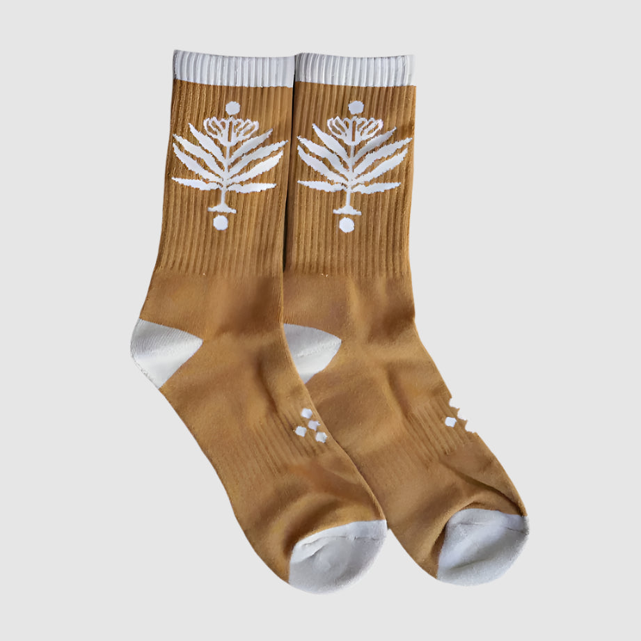 Gold socks with bold, white, symetrical flower designs on side. One size fits all. Made from 100% cotton, soft and breathable, keeping your feet happy all day long!