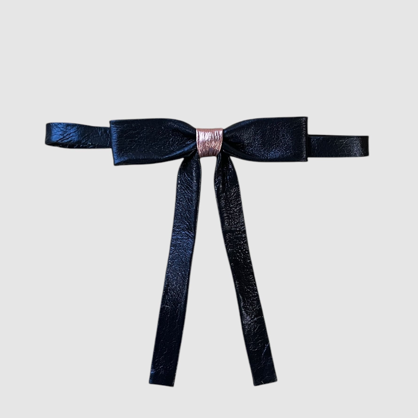 A midnight blue and cotton candy pink metallic leather neck bow with a small brass buckle closure.