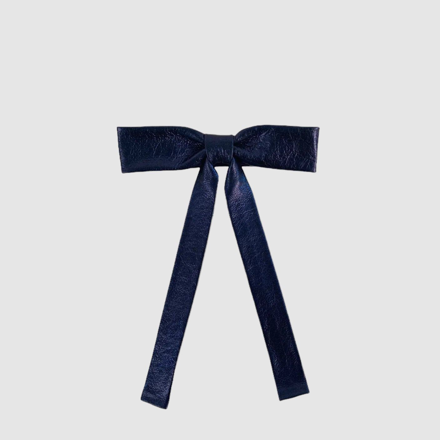 A midnight blue neck bow with metallic leather finish and a small brass buckle, displayed against a white background.