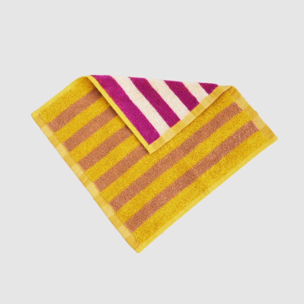 A yellow and pink striped cotton terry wash cloth.