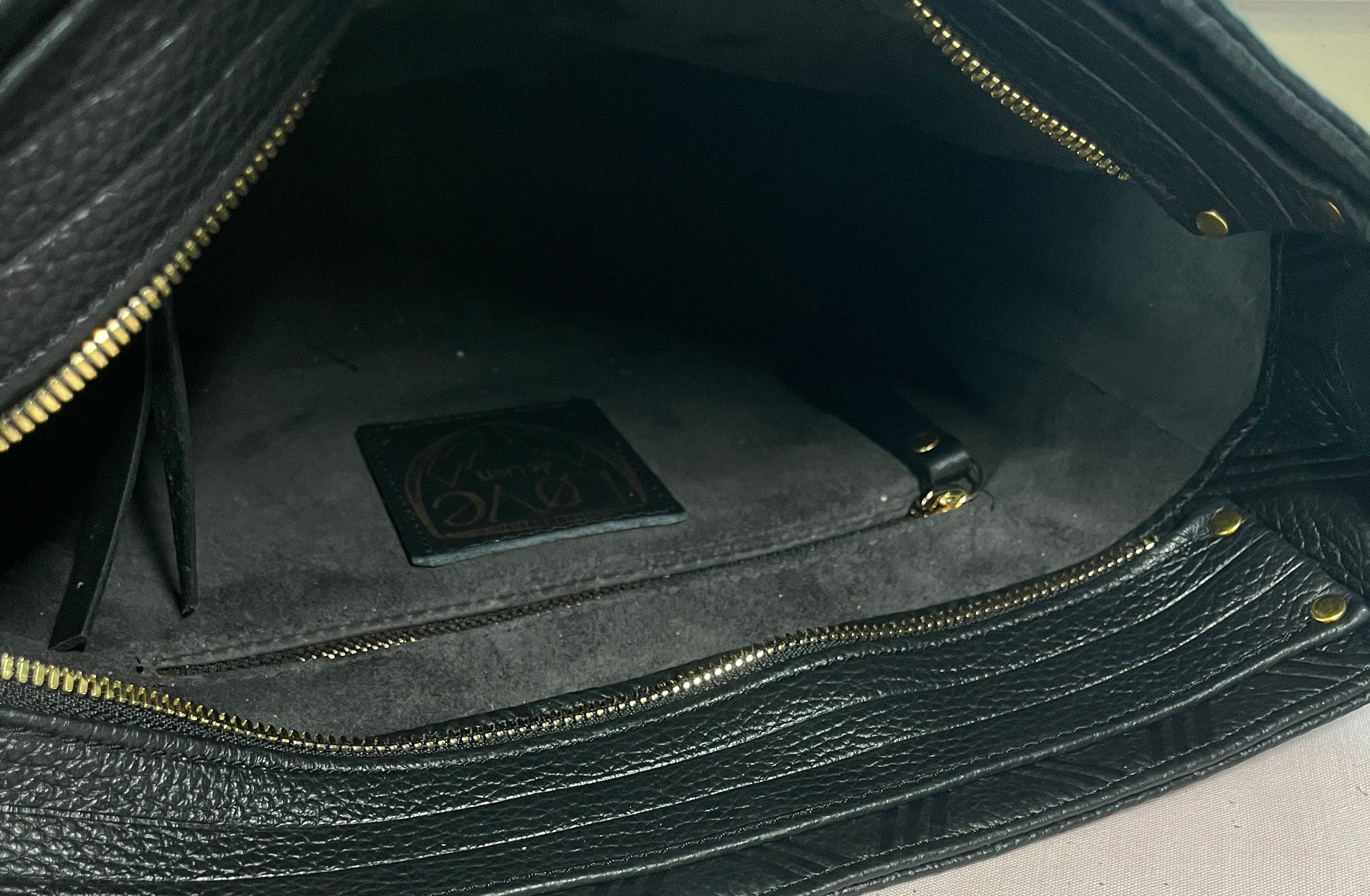 Black leather bag detail, embossed stripe pattern, brass zipper, leather lining, interior Mellow Dawn, boutique leather handbags . Handmade in Tucson, Arizona