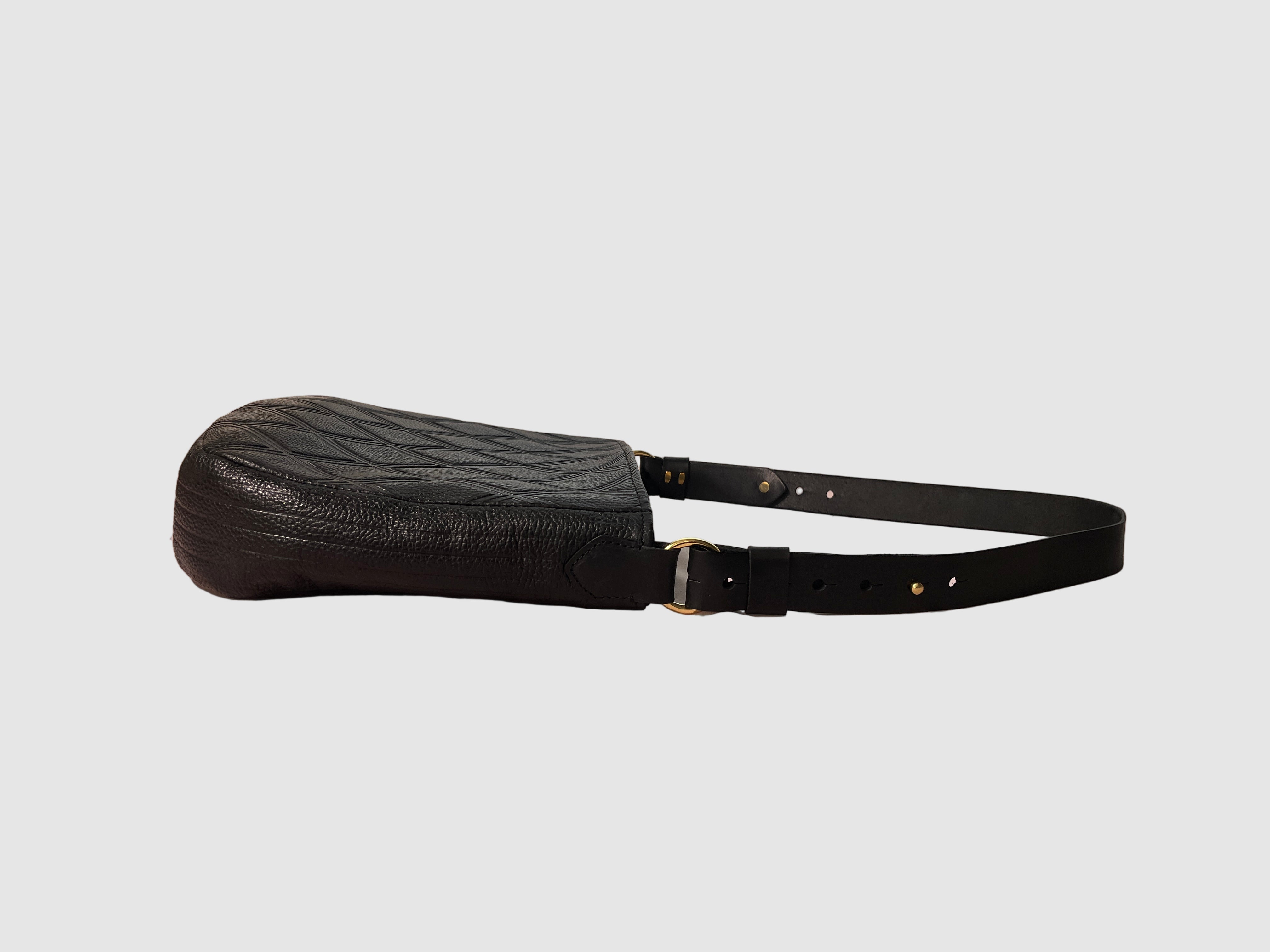 Black leather bag detail, quilted embossed pattern, brass ring attaching leather strap Mellow Dawn, boutique leather handbags . Handmade in Tucson, Arizona