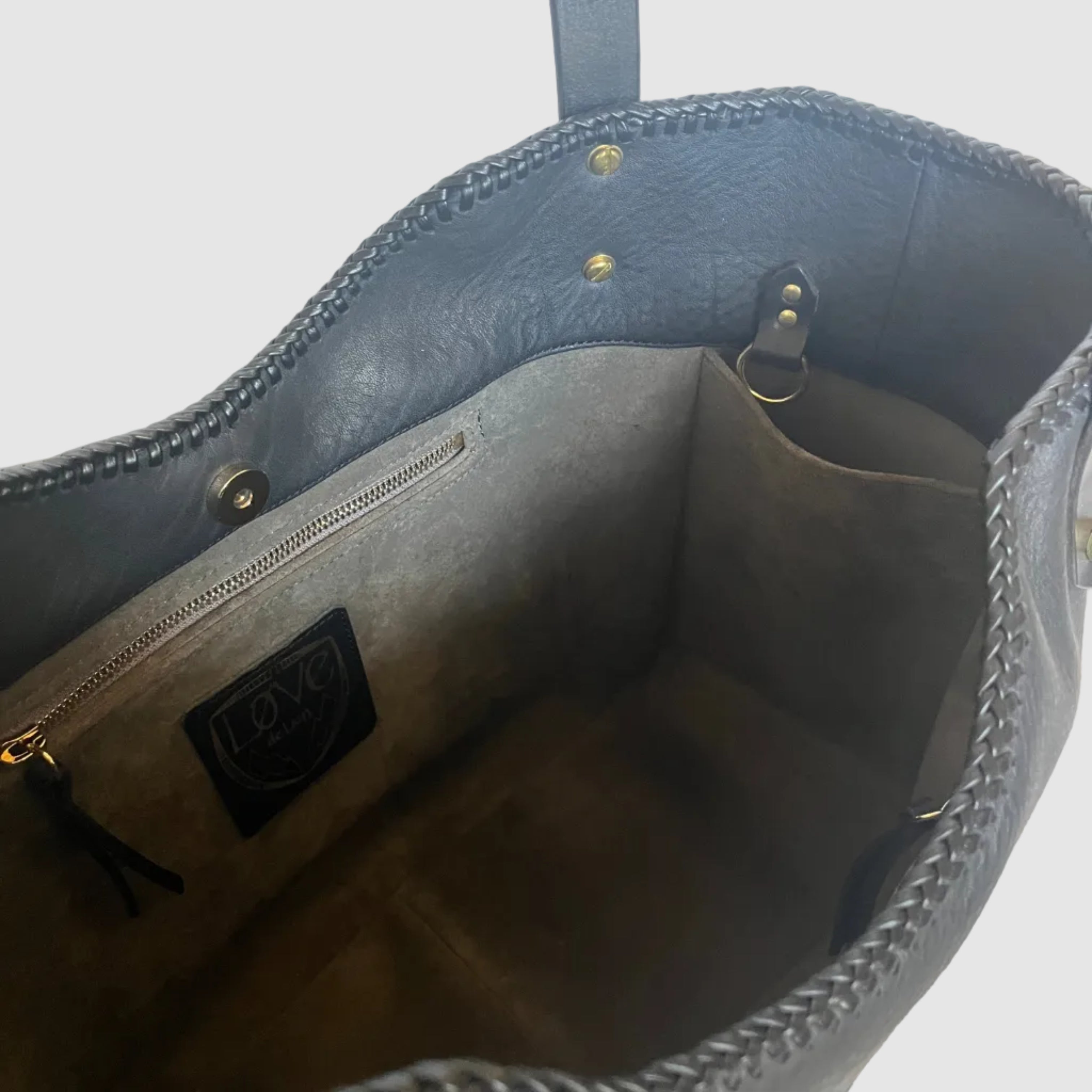 Interior of Outisder Carry All. Black leather, lack leather lacing, Grey suede lining with two zipper pockets