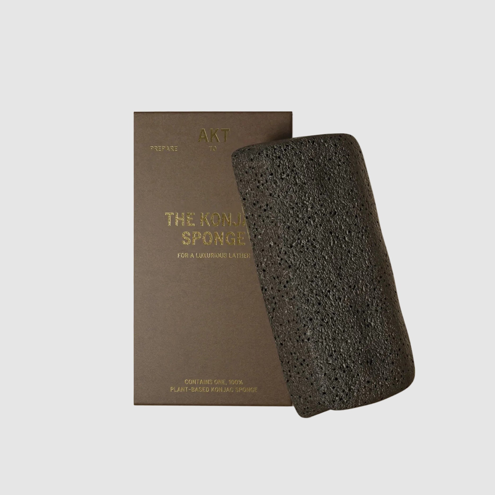 Black konjac spopnge with a brown box on a beige background