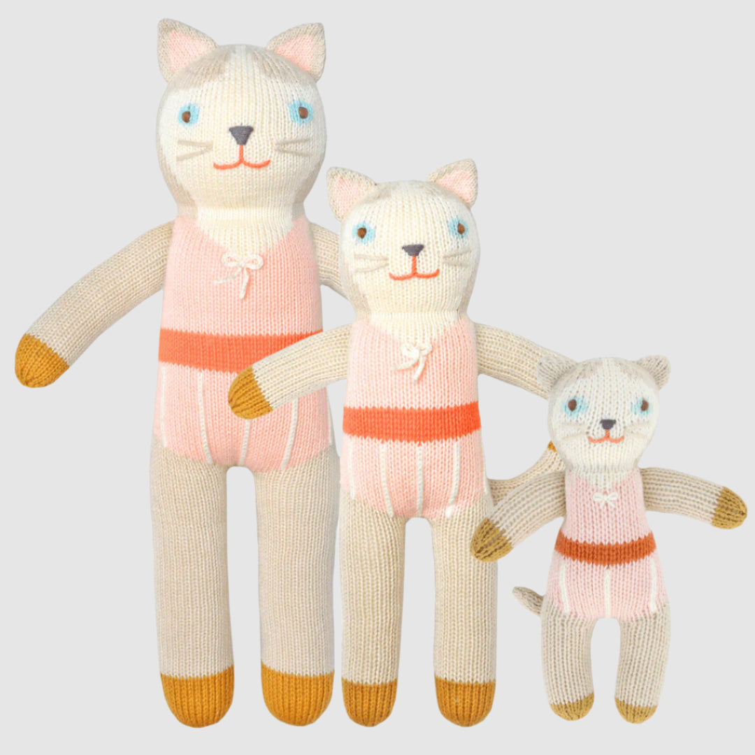 Three knitted cat toys in various outfits on a white background