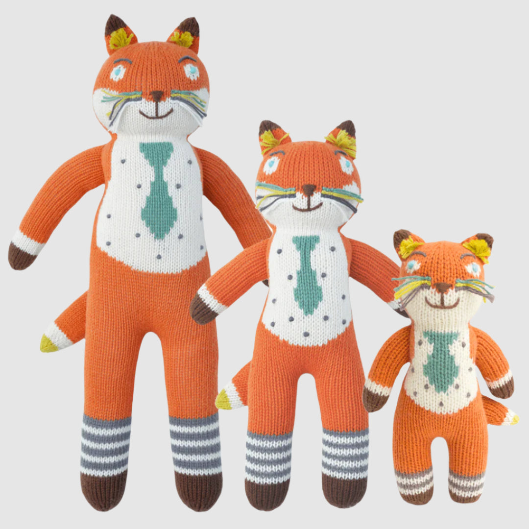 Three knitted fox toys of different sizes on a white background