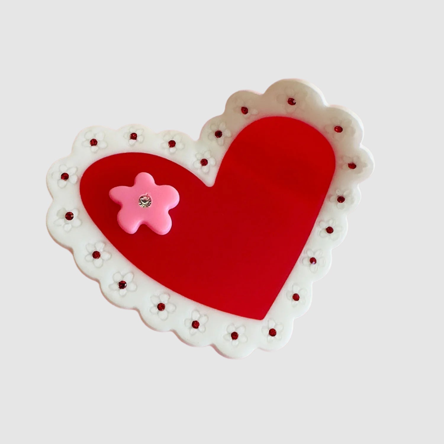 A Centinelle 'laced heart' style hair claw on a light grey background.