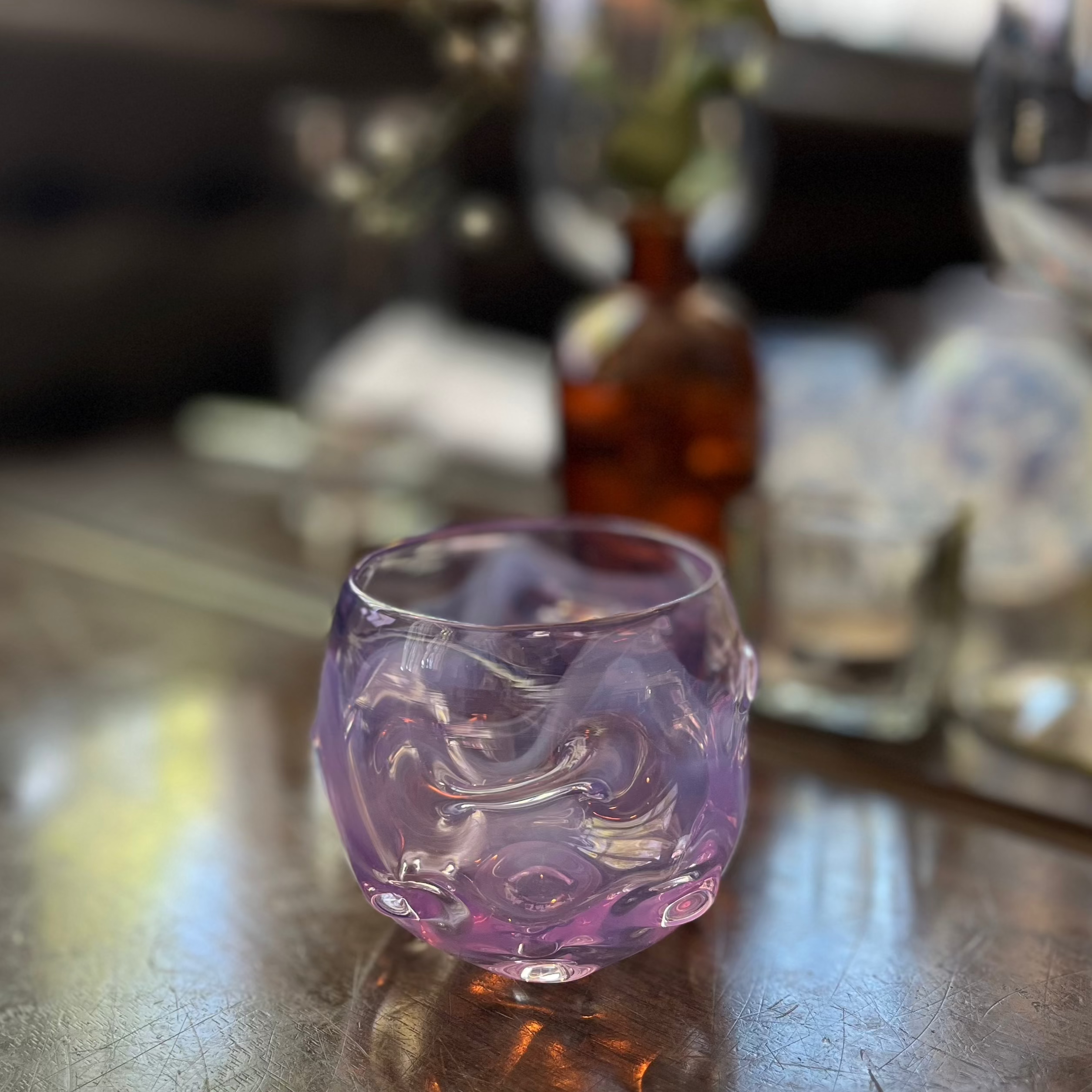 Translucent purple glass object on a wooden table.