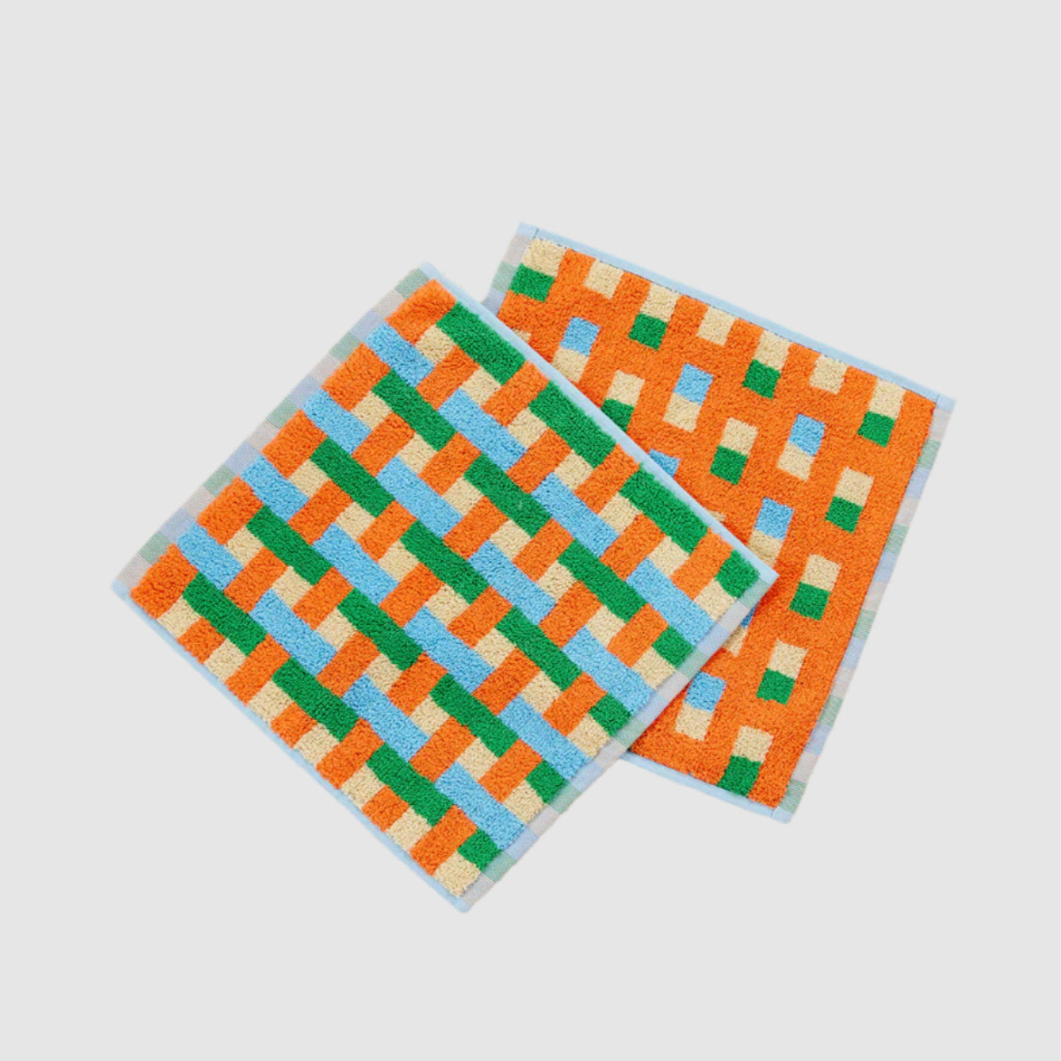 Two colorful checkered towels on a light gray background