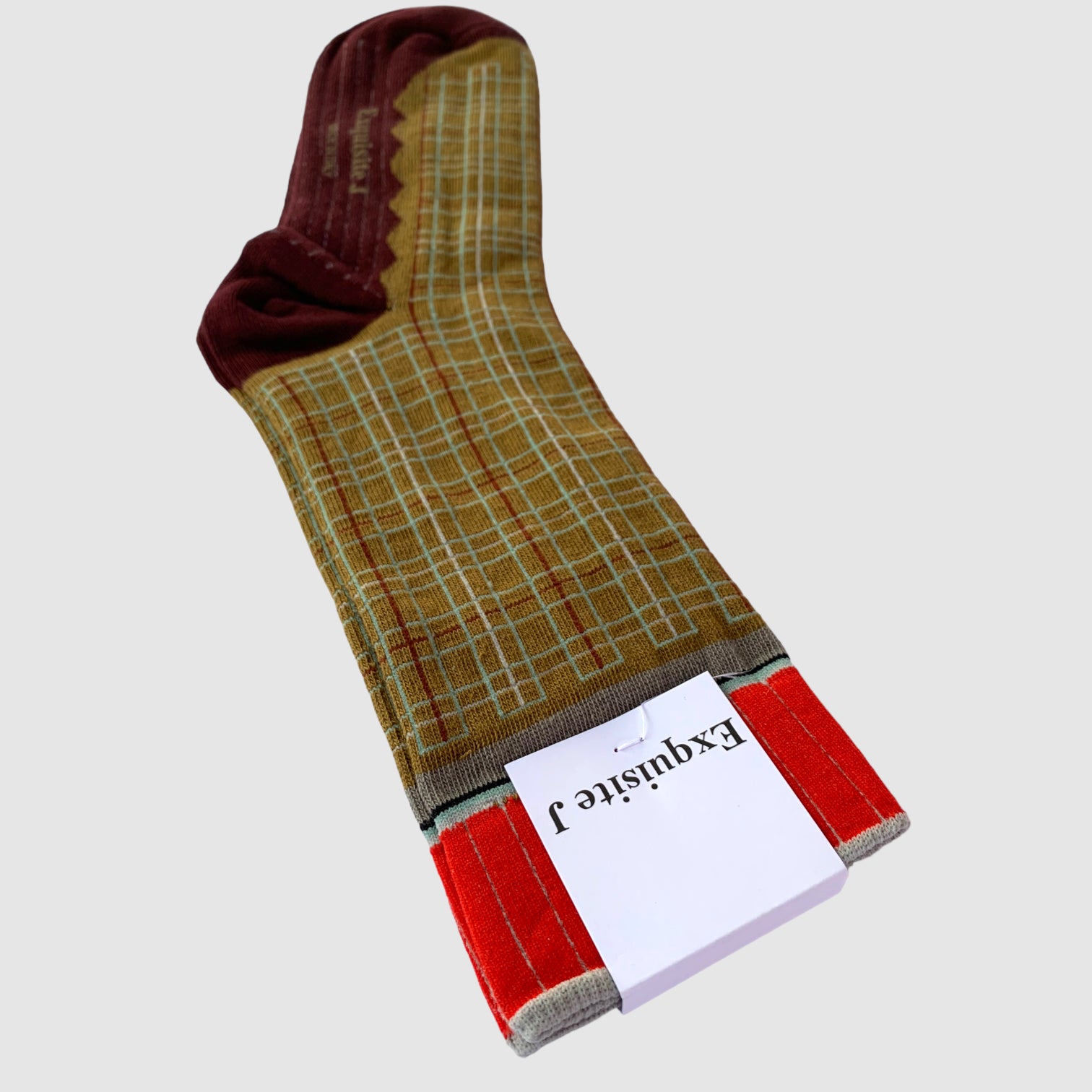 A pair of socks with a geometric pattern, predominantly brown with green and red accents.