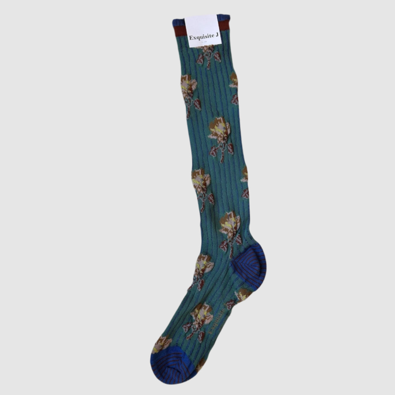 Knee-high teal and pale pink floral socks with a royal blue toe, displayed on a hanger.