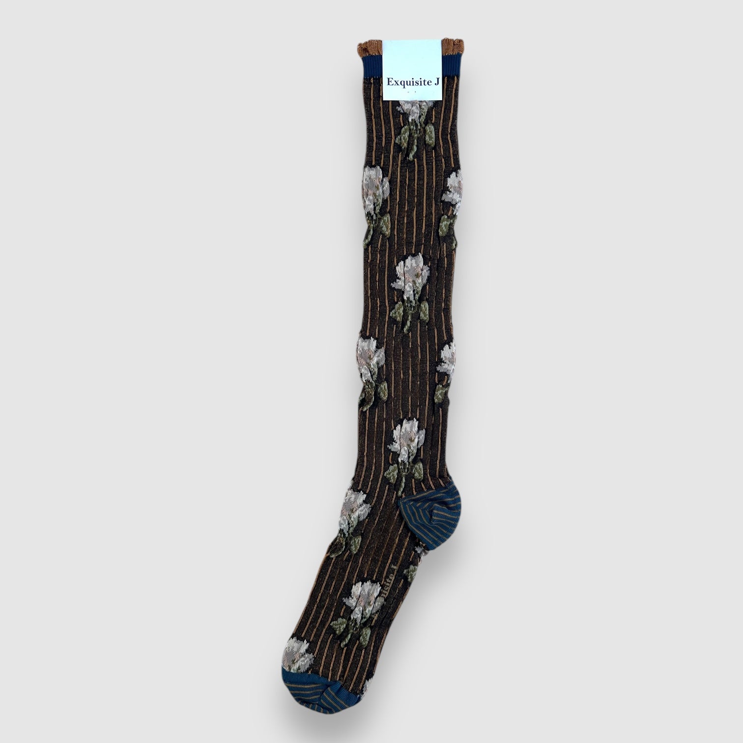 Knee-high socks with floral pattern in shades of grey and blue with a rust-colored toe.