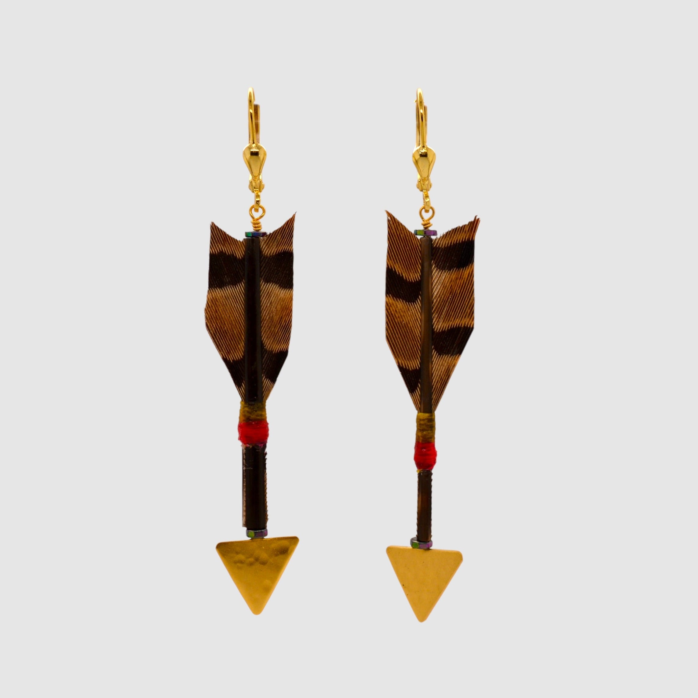 Brown pheseant feather arrow earrings with vermeil arrowheads and leverback clasps designed and handmade in Tucson, Arizona by Sofie Albertsen. Displayed on a light grey background.