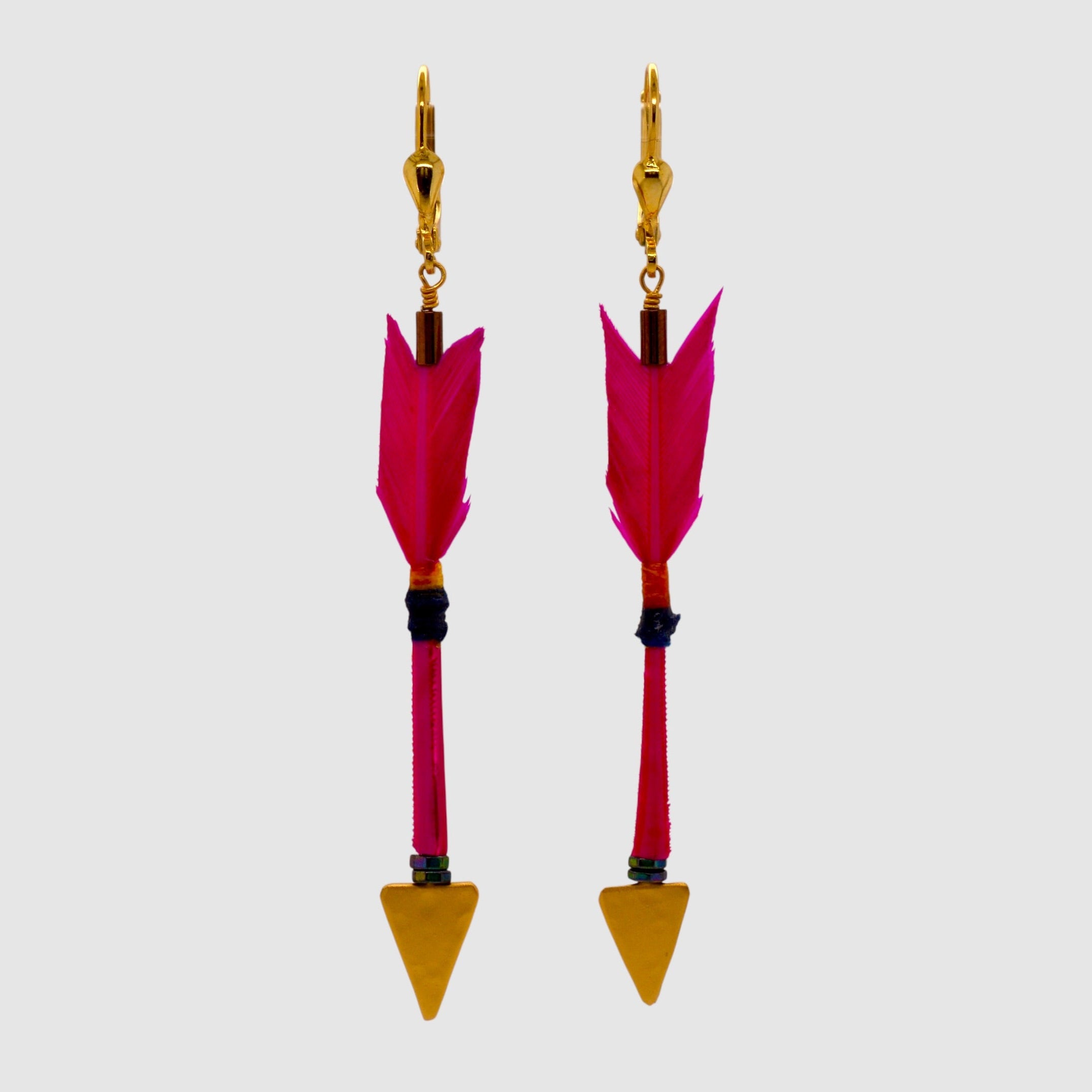 Hot pink feather arrow earrings with vermeil arrowheads and leverback clasps designed and handmade in Tucson, Arizona by Sofie Albertsen. Displayed on a light grey background.