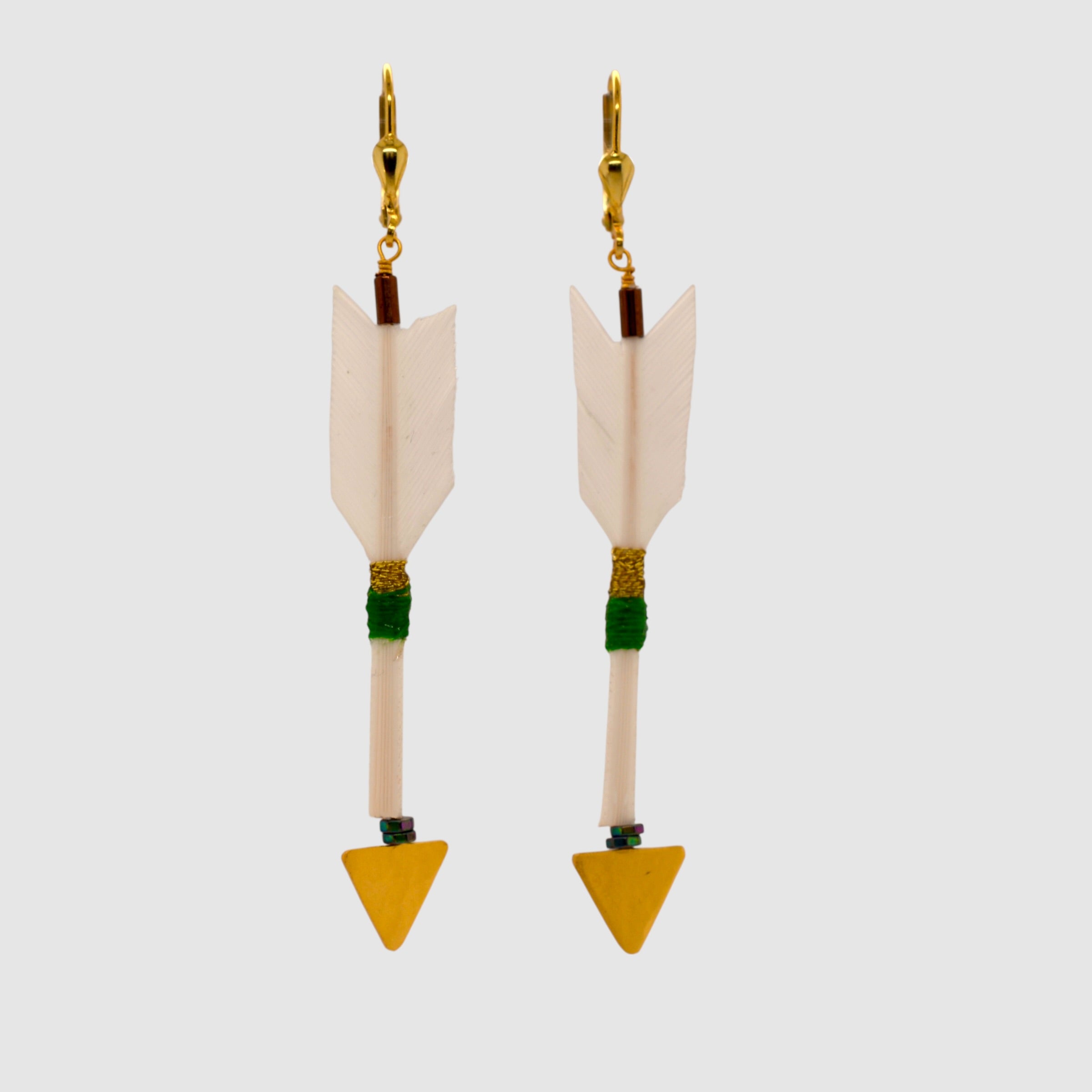 White feather arrow earrings with vermeil arrowheads and leverback clasps designed and handmade in Tucson, Arizona by Sofie Albertsen. Displayed on a light grey background.