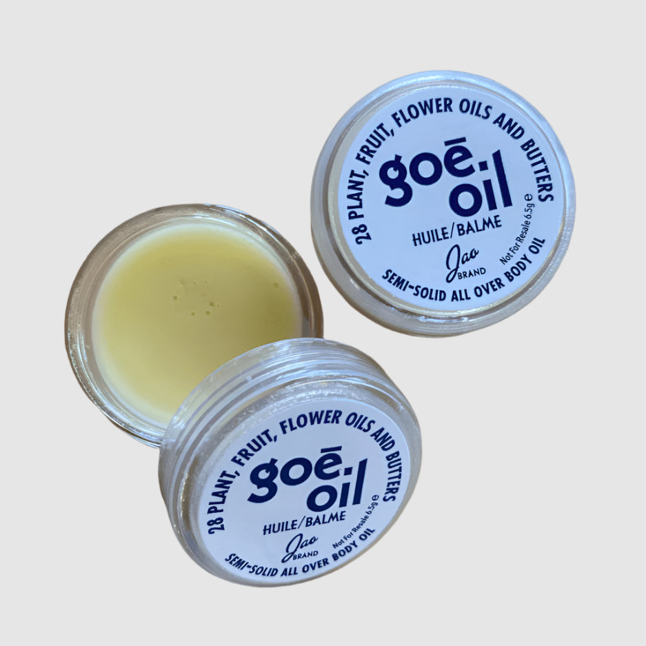 A tube of GOÉ OIL body oil with a white and silver design, indicating that it is a natural beauty product for the body.