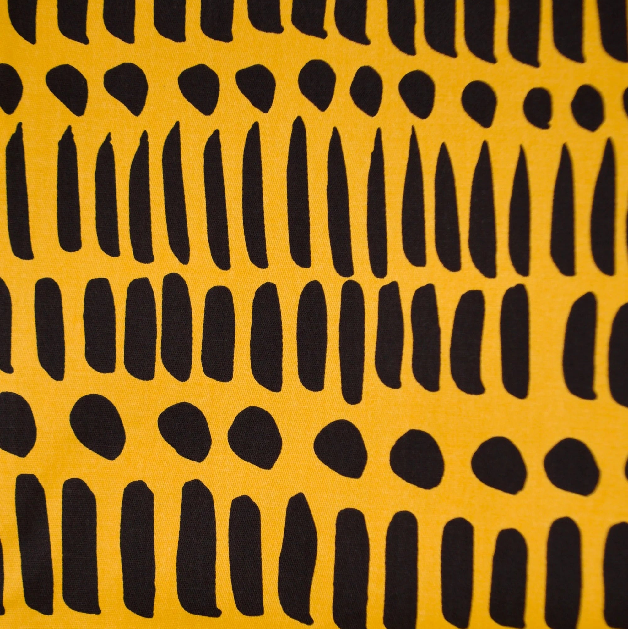 Close-up of Noowork's "Dorcas Code" pattern featuring a yellow background and various black stripes and dots.