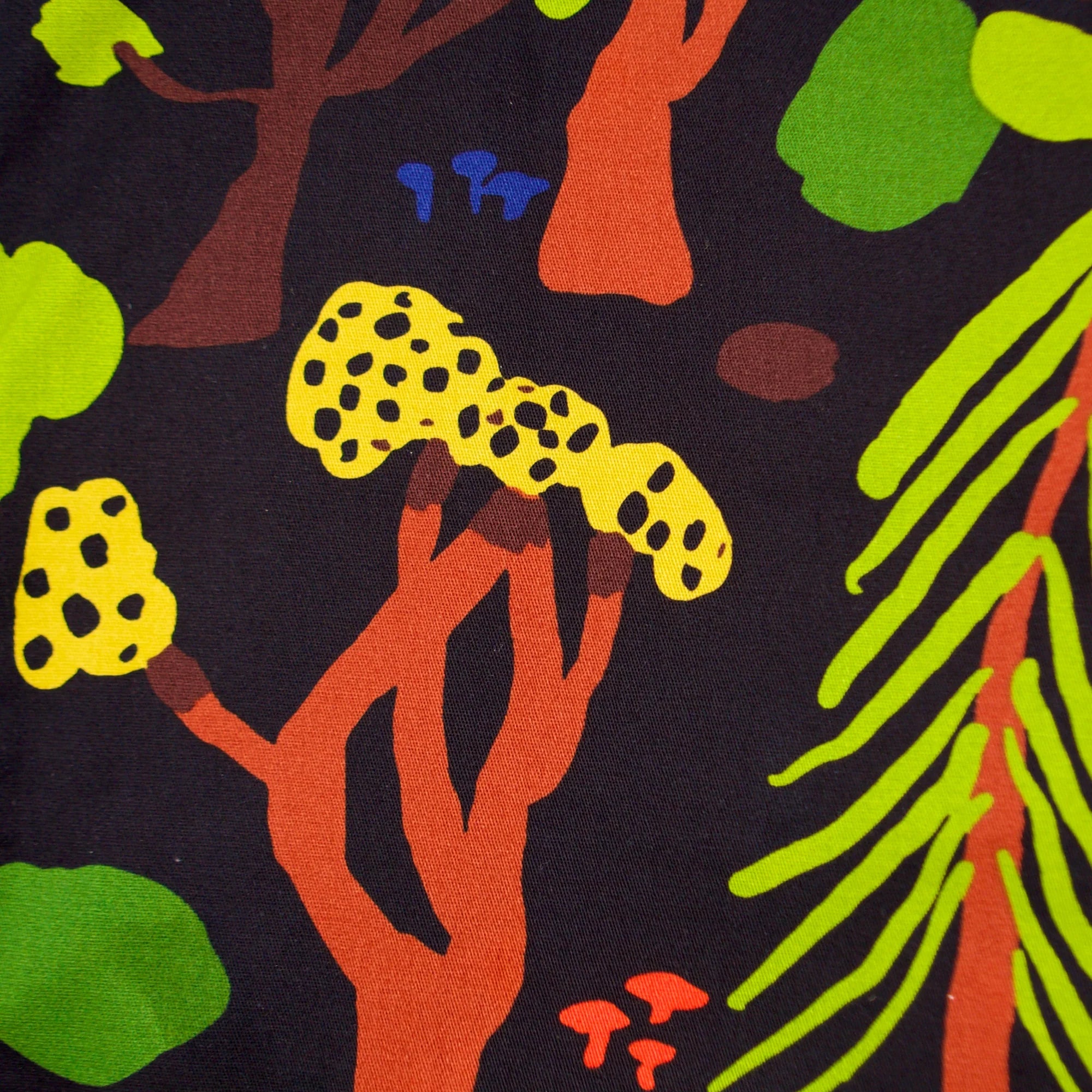 Close-up of Noowork's "Forager" pattern featuring yellows, oranges, browns, greens, blues and blacks in a geometric style resembling a forrest.