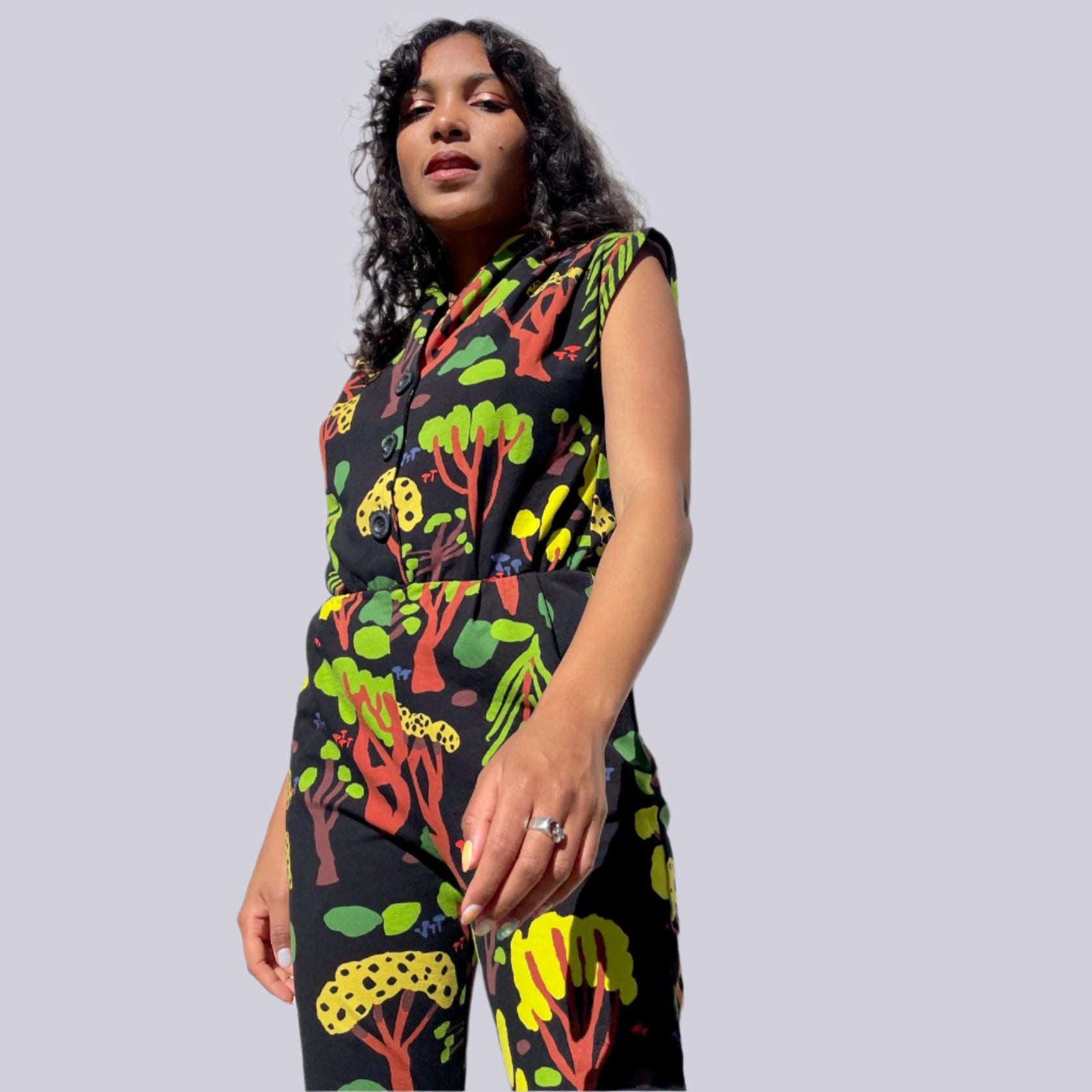 Noowork's "Forager" pattern featuring yellows, oranges, browns, greens, blues and blacks in a geometric style resembling a forrest styled on a young person. Light purple background.