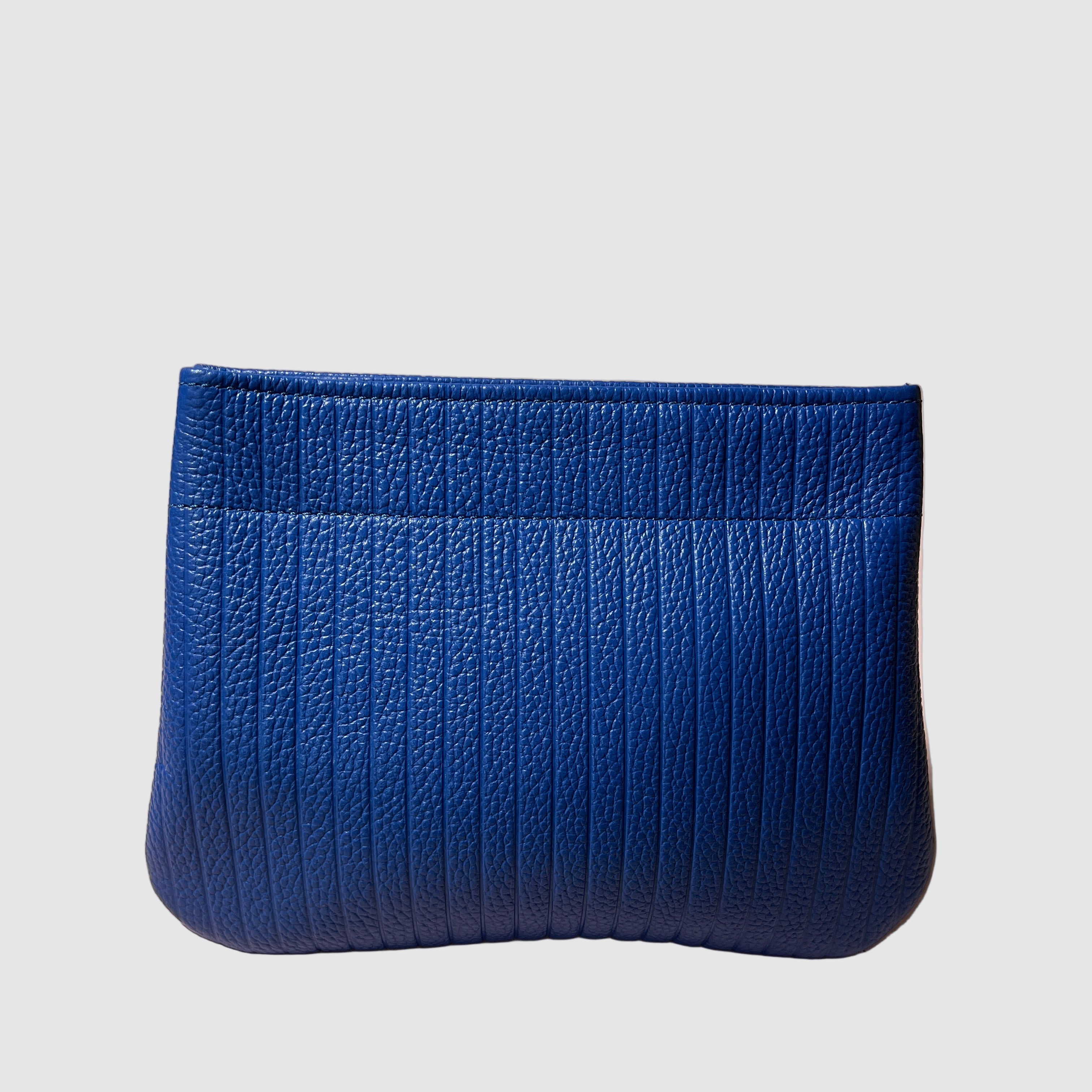 Embossed cobalt blue handmade leather clutch on a light grey background. Bag made by Mellow Dawn in Tucson, Arizona.