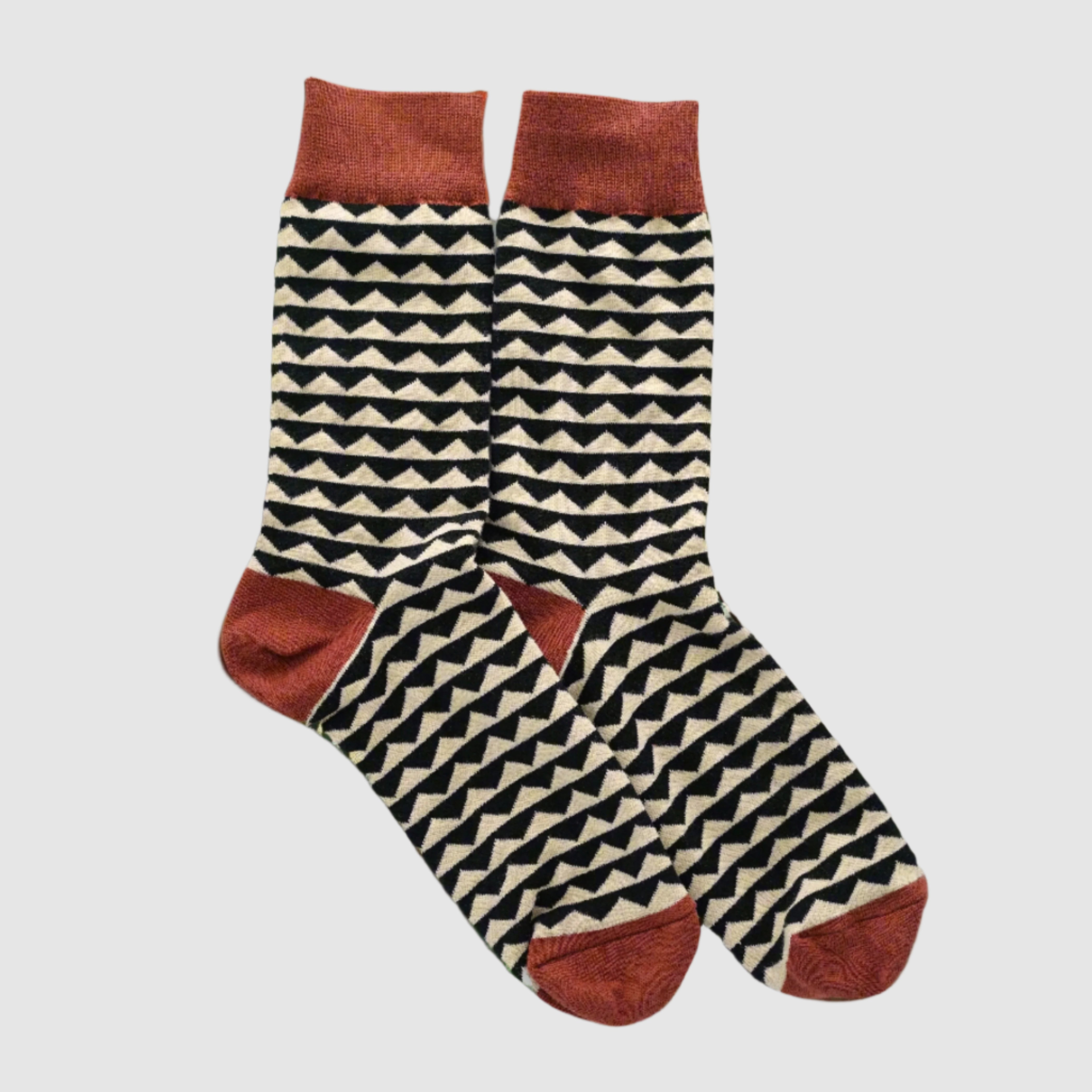 Pair of socks with geometric pattern and red accents on a beige background