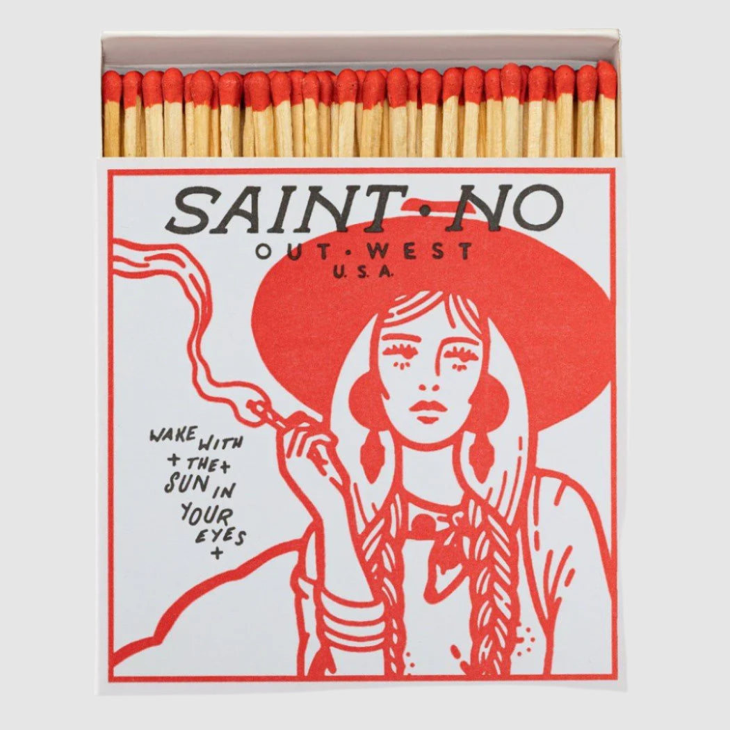 Matchbox with a design of a woman in a red hat and text 'SAINT NO Out West USA'.