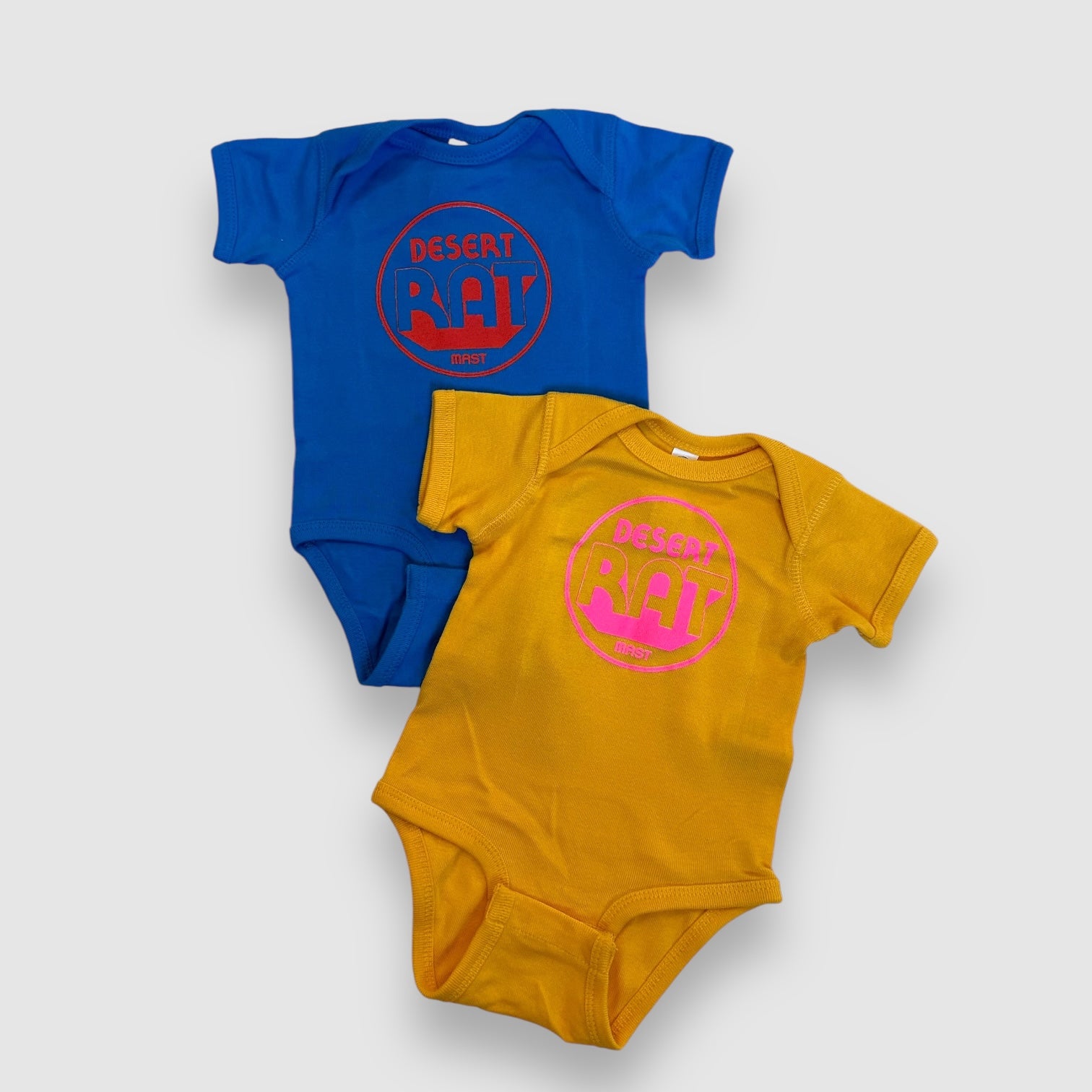 Desert Rat Baby onsies in blue with red and yellow with pink available at MAST