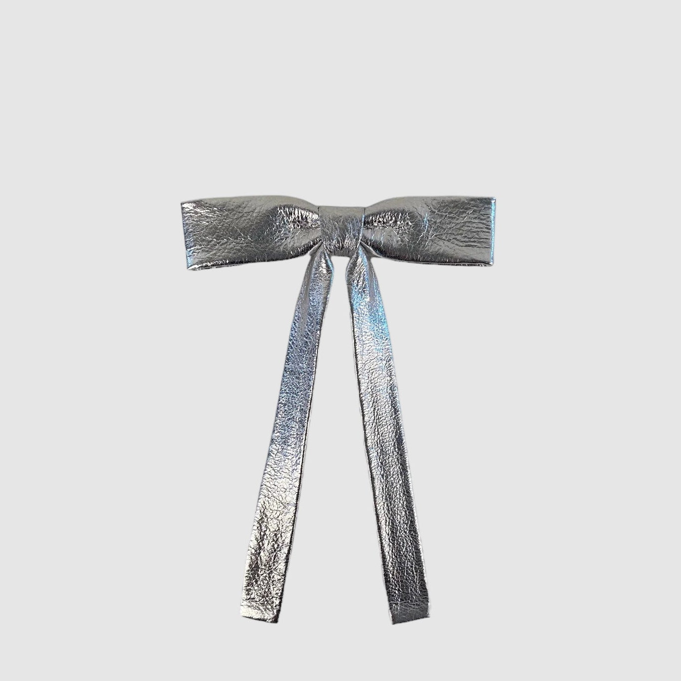 A thin metallic leather neck bow with a silver body and a blue central wrap, featuring a small brass buckle.