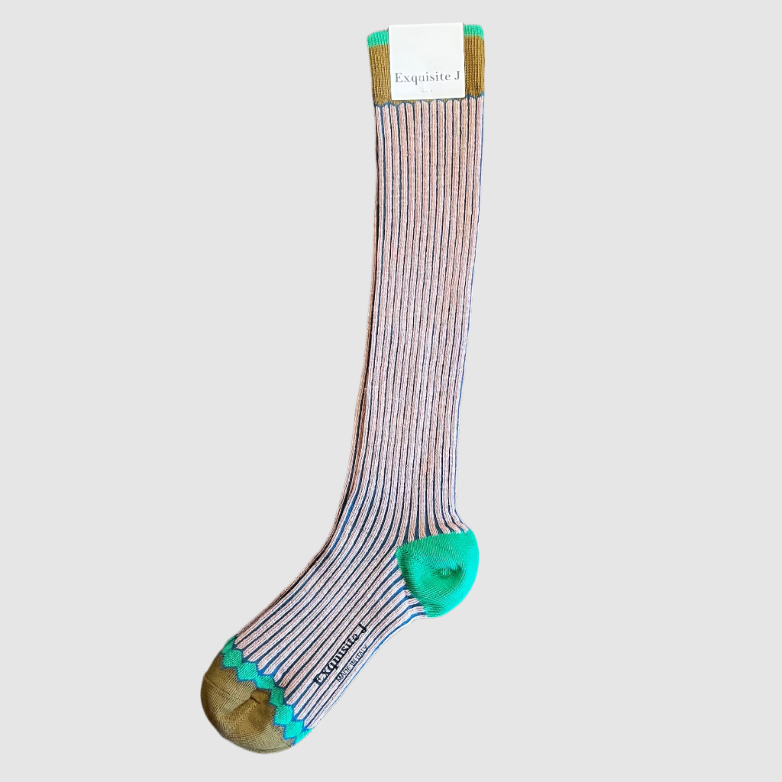 Striped sock with green accents on a wooden surface next to a laptop.