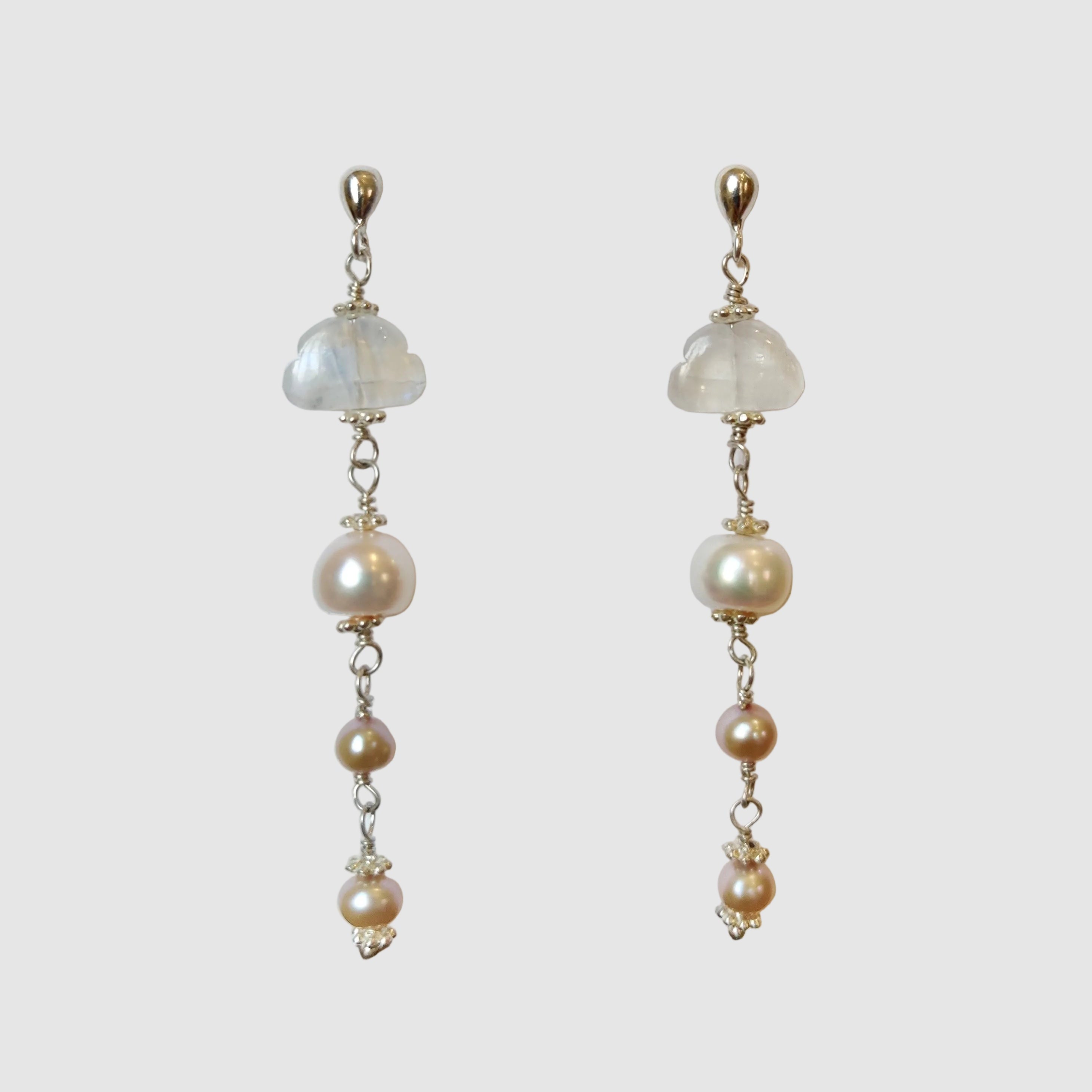 Pearl earrings on a white card with a blurred background