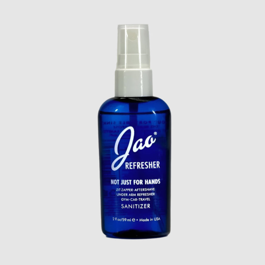 A blue, 2fl oz spray bottle of the Jao Refresher on a grey background.