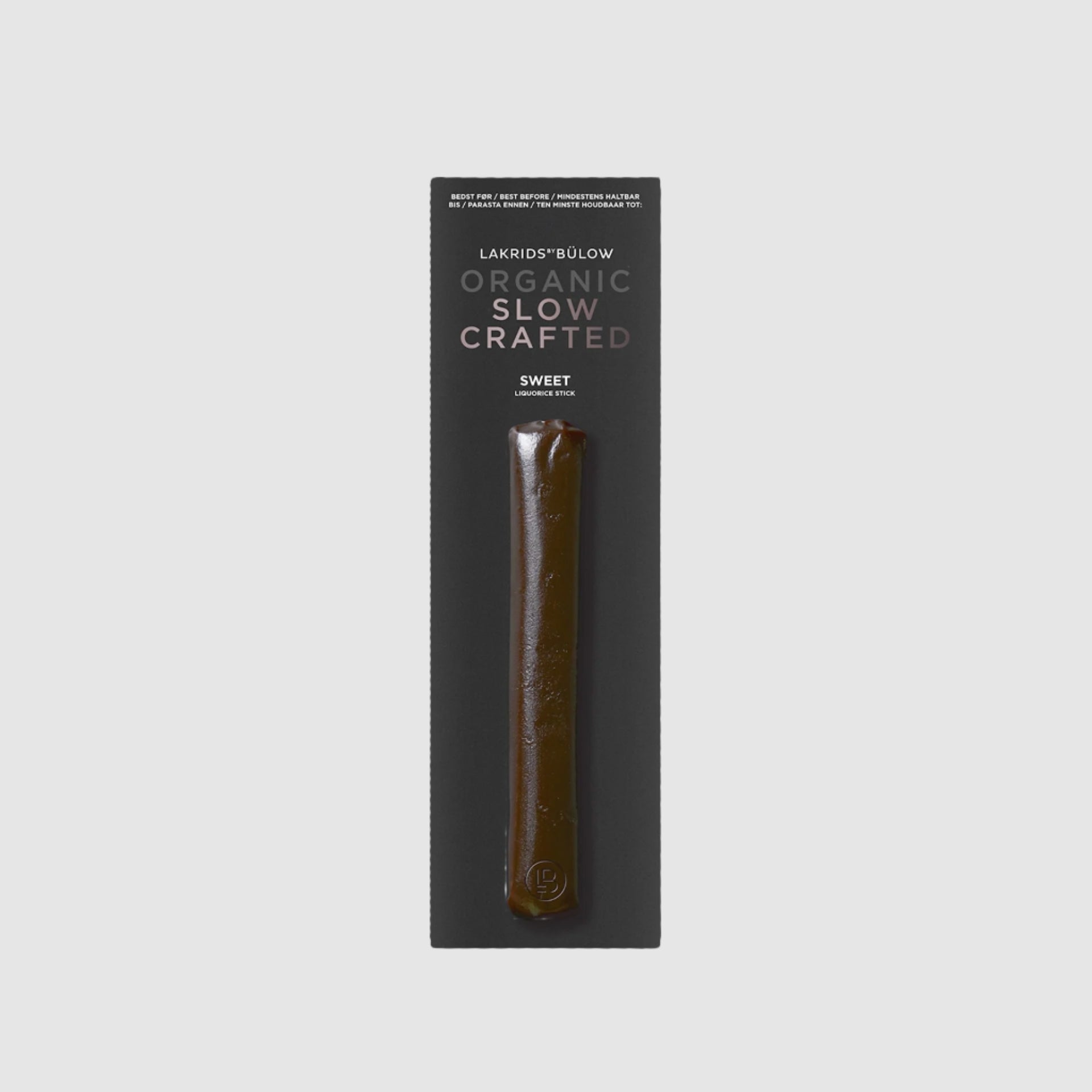 A piece of Lakrids by Bulow 1-Sweet flavored licorice stick in packaging on a grey background.