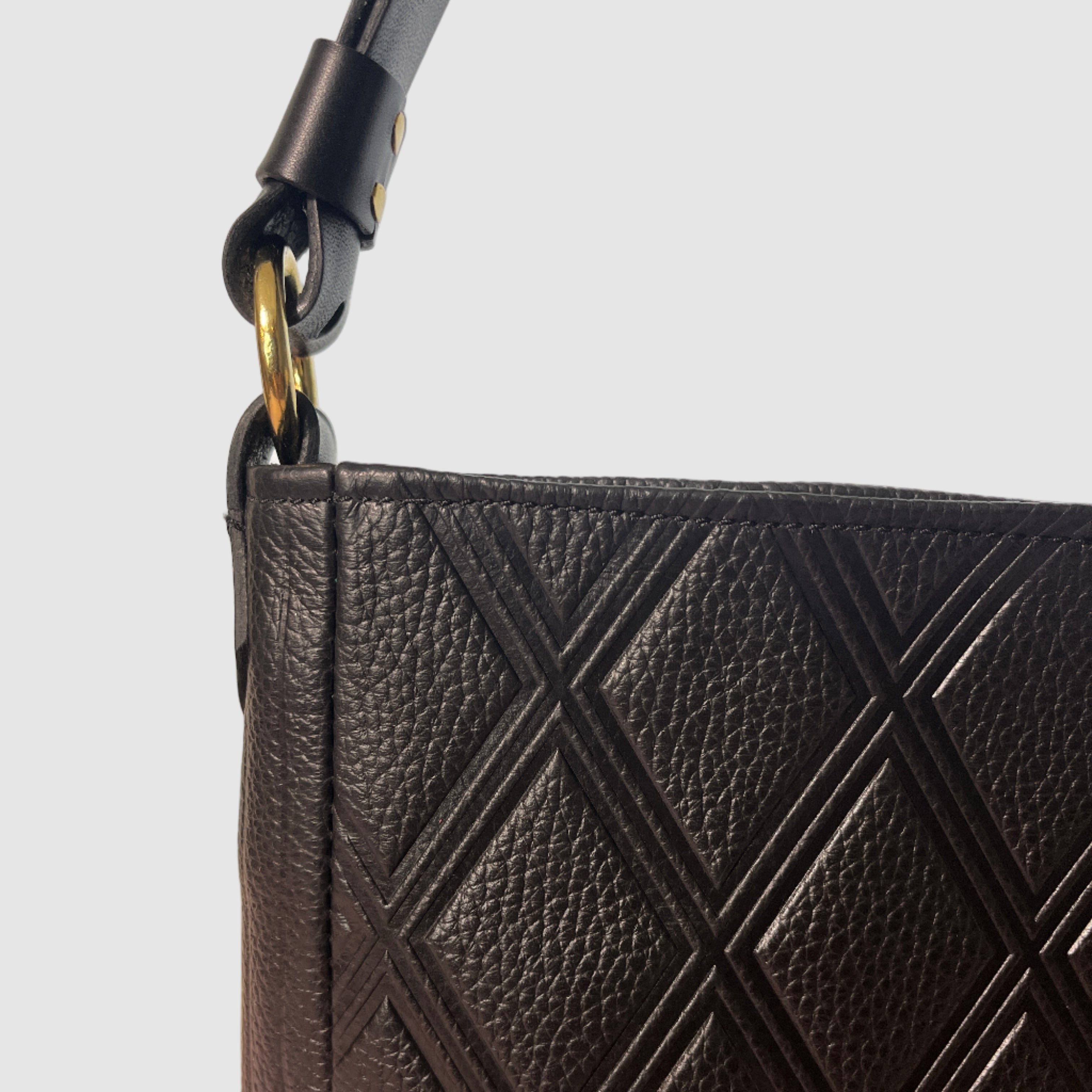 Black leather bag detail, quilted embossed pattern, brass ring attaching leather strap Mellow Dawn, boutique leather handbags . Handmade in Tucson, Arizona