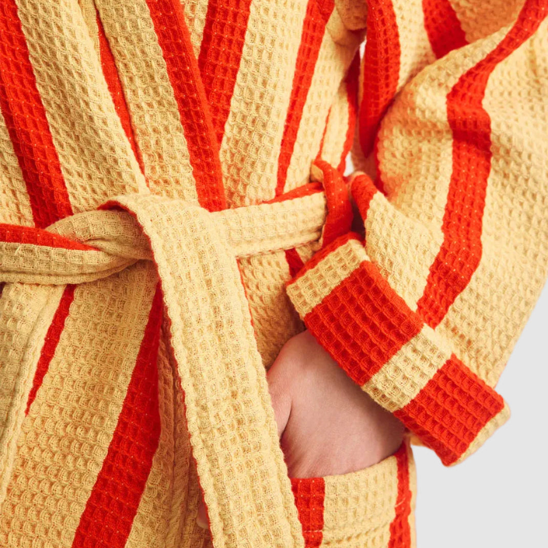 Close-up of a red and yellow striped robe with a white background