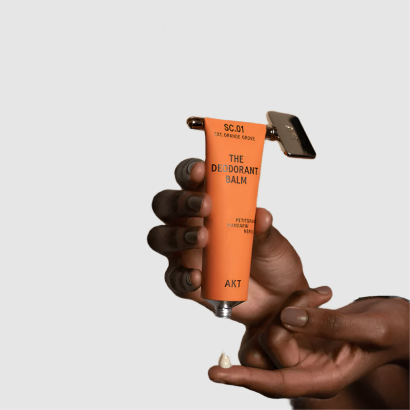 Orange deodorant balm with a applicator held by a hand, against a beige background with promotional text.