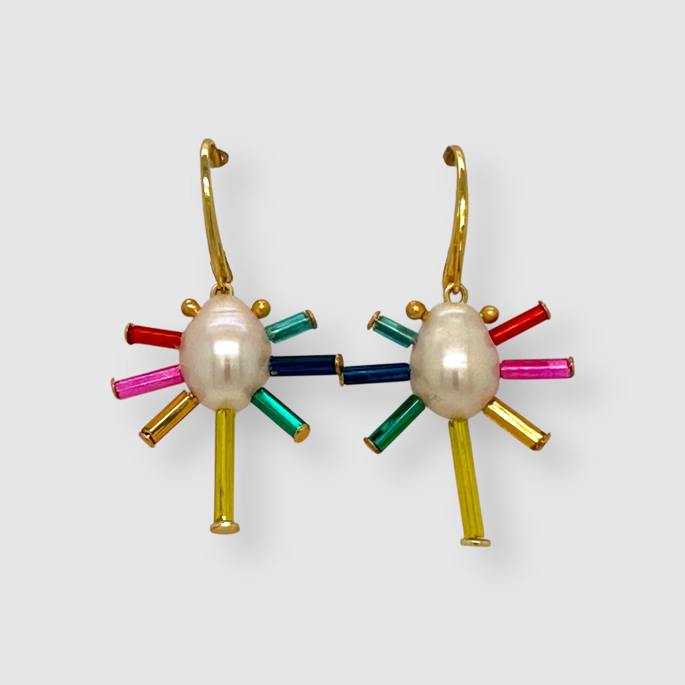 Pair of earrings handmade by Sofie Albertsen in Tucson, Arizona. Pearl center with vintage glass beads strung on a vermeil leverback clasp. Displayed on a light grey background.