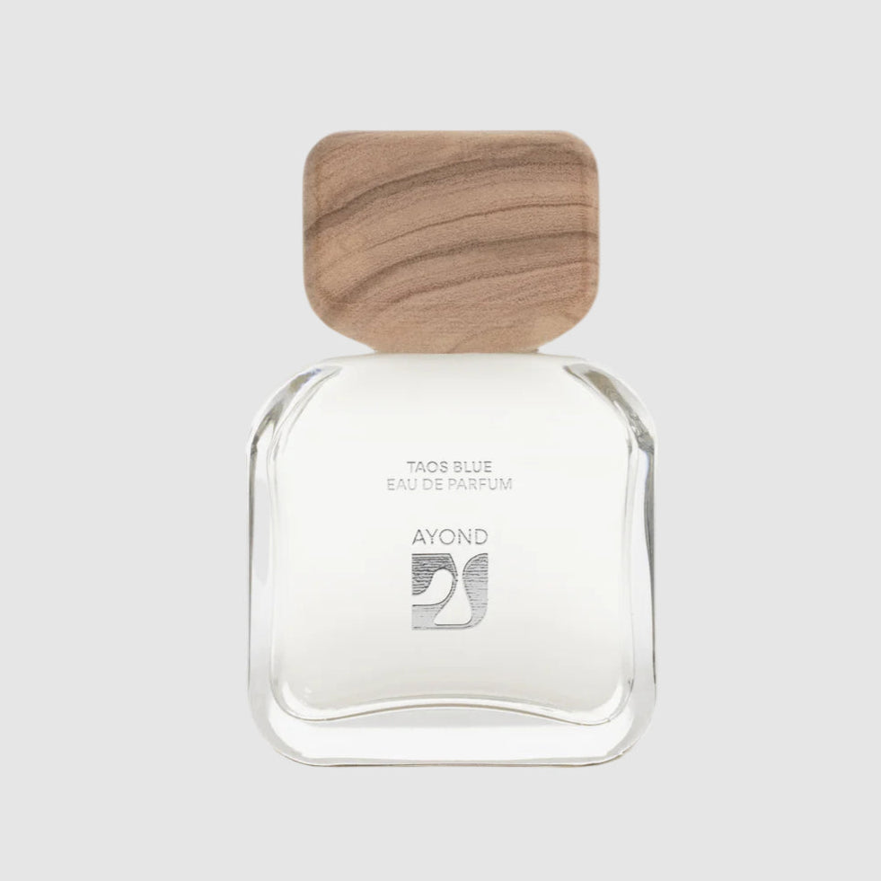 Ayond's Taos Blue eau de parfum clear bottle with wooden cap on a light grey background