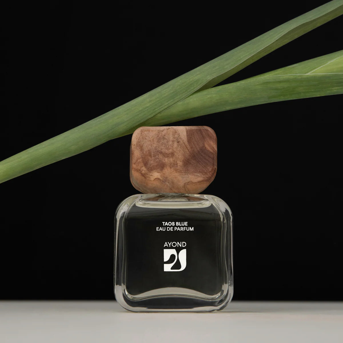 Ayond's Taos Blue eau de parfume bottle with wooden cap on a black background