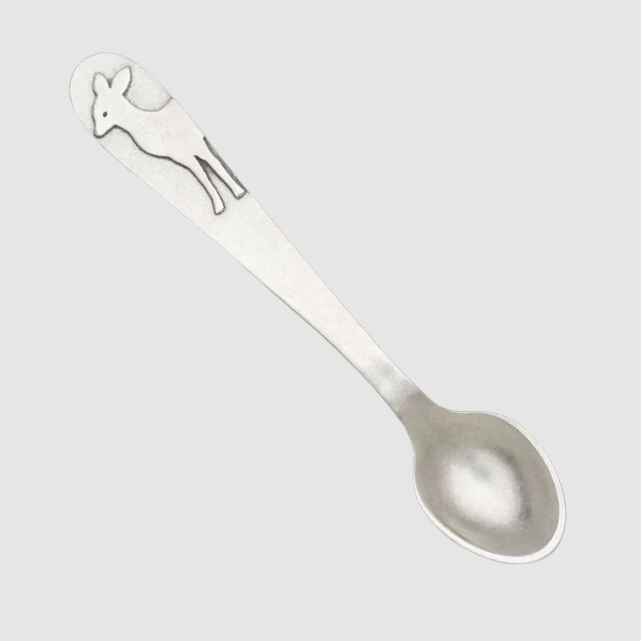 Silver spoon with a deer design on a light gray background