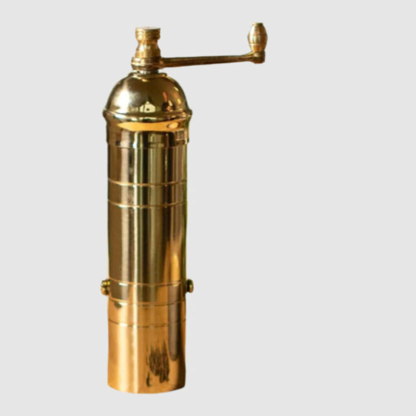 Gold pepper grinder on a white background
