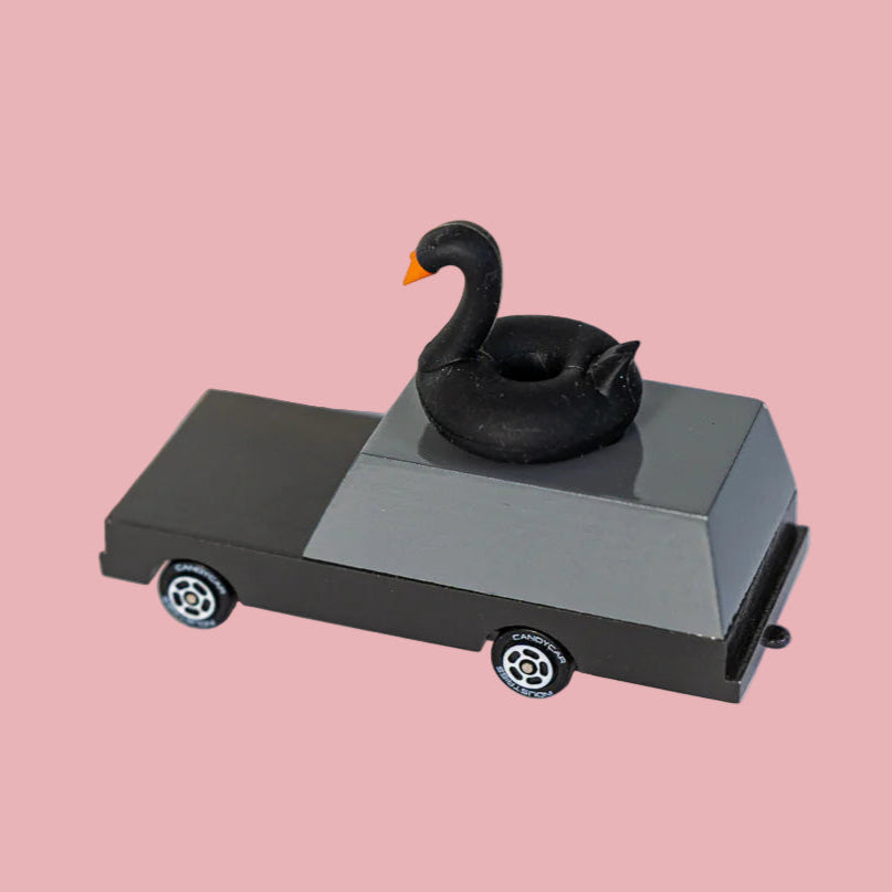 Black swan wagon of candylab cars, handmade wooden toys for kids, on a light pink background