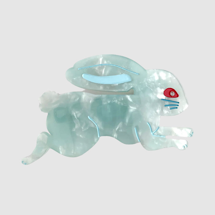A blue, centinelle, ligonberry bunny barrette hair clip on a light grey background