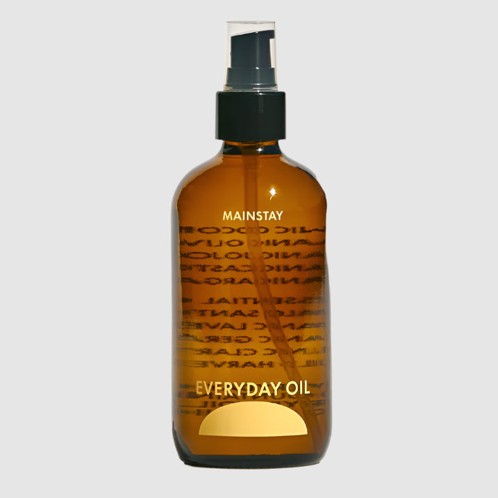 Brown bottle of 'Everyday Oil' with a black spray nozzle on a white background