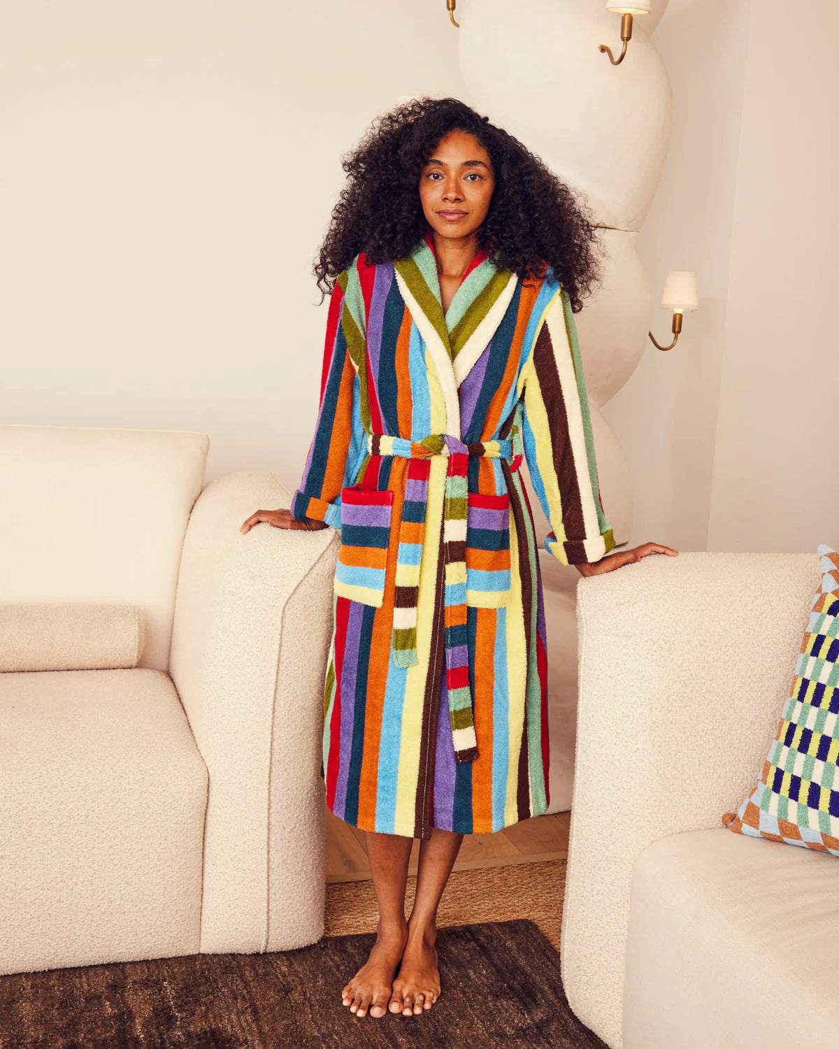 Woman wearing a DusenDusen colorful striped robe in a living room setting