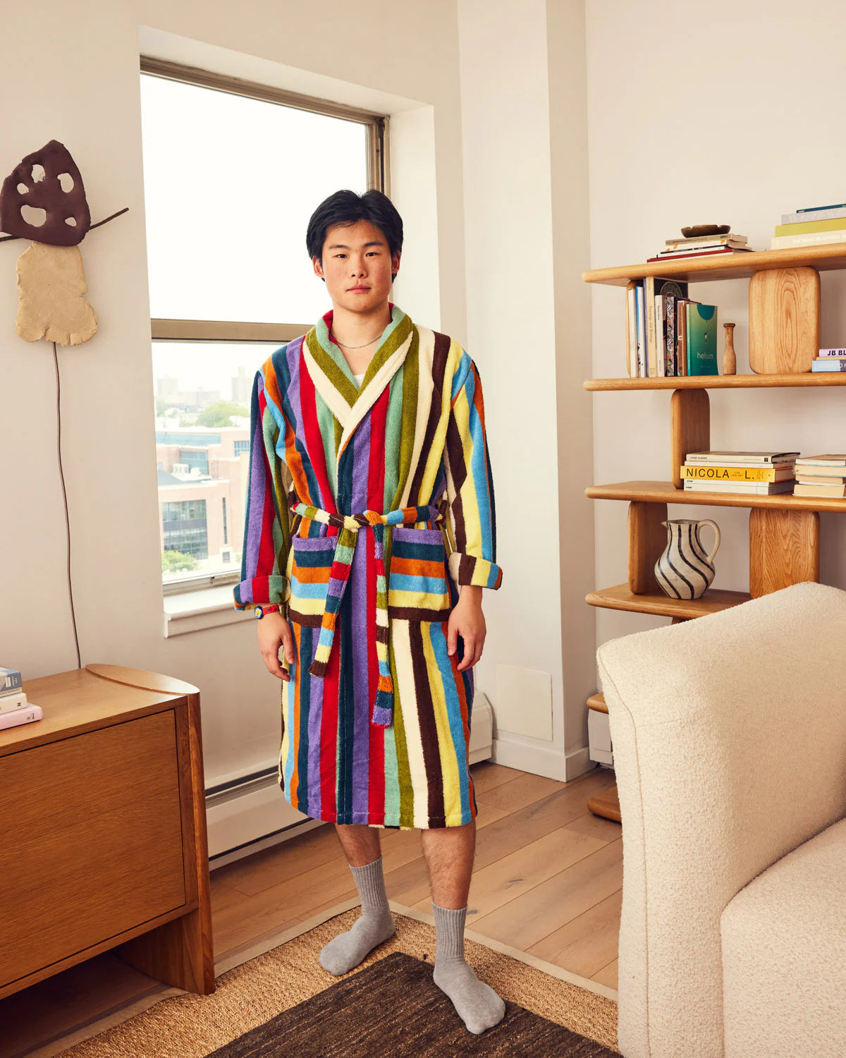 Person wearing a Dusen Dusen colorful striped robe in a cozy living room