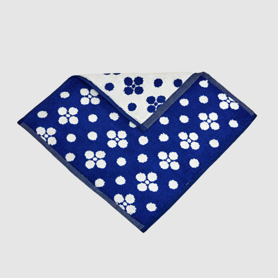 Blue wash cloth with white dots on a lgith grey background