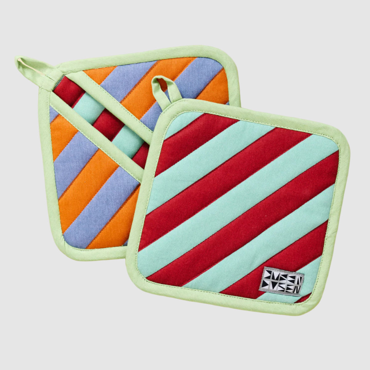 Pair of colorful striped Dusen Dusen pot holders on a light grey background