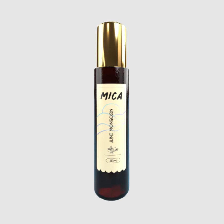 Bottle of Mica perfume with gold cap on a light gray background